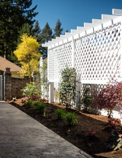 A Greenhaven Landscapes design customer's Vancouver WA wood privacy screen and shrubbery along a pathway