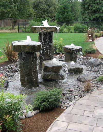 A Greenhaven Landscapes design customer's Vancouver WA back yard walkways with stone bubbler water feature