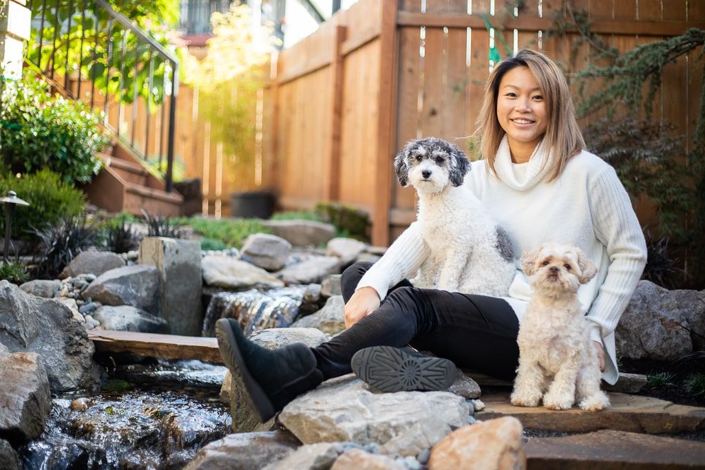 A woman and her two dogs next to a Greenhaven Landscapes waterfall water feature in Vancouver WA