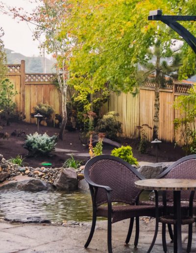 A Greenhaven Landscapes-designed water feature - a Vancouver WA backyard waterfall with stone pathway and patio