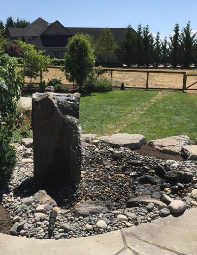A Greenhaven Landscapes-designed stone bubbler water feature and stone patio in Vancouver WA