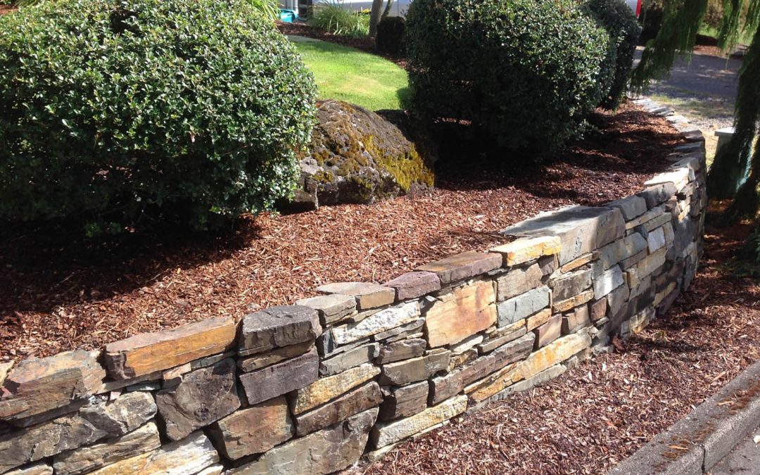 A Greenhaven Landscapes-designed customer's Vancouver WA masonry retaining wall and shrubbery