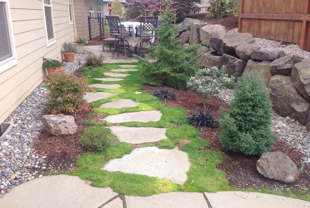 A Greenhaven Landscapes-designed customer's Vancouver WA stone stepping stones, rock wall, and rock retaining wall with moss between steps