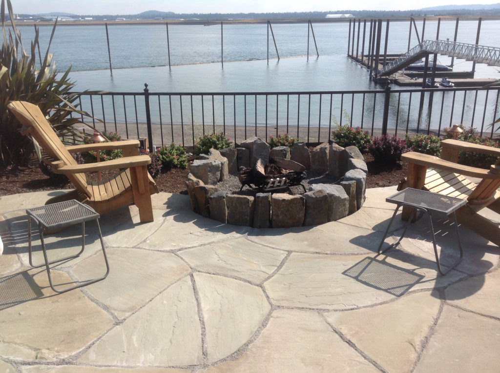 Patio with a fire pit and view of the river