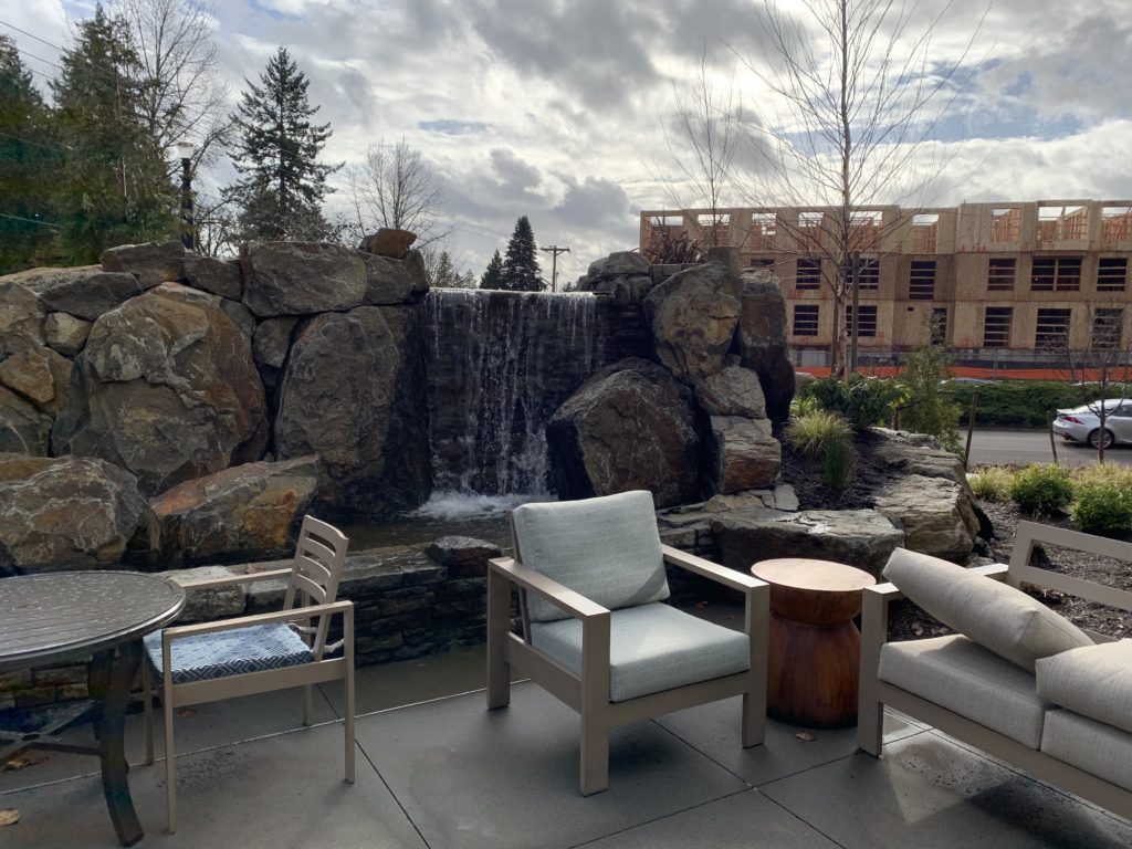 Patio with chairs next to a water feature in Lake Oswego at The Springs