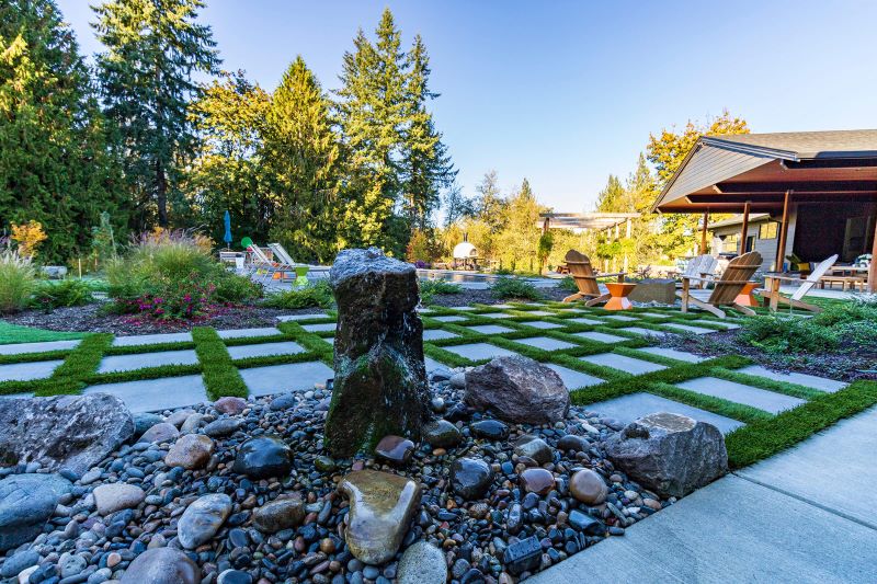 rock water feature surrounded by zen inspired concrete pavers