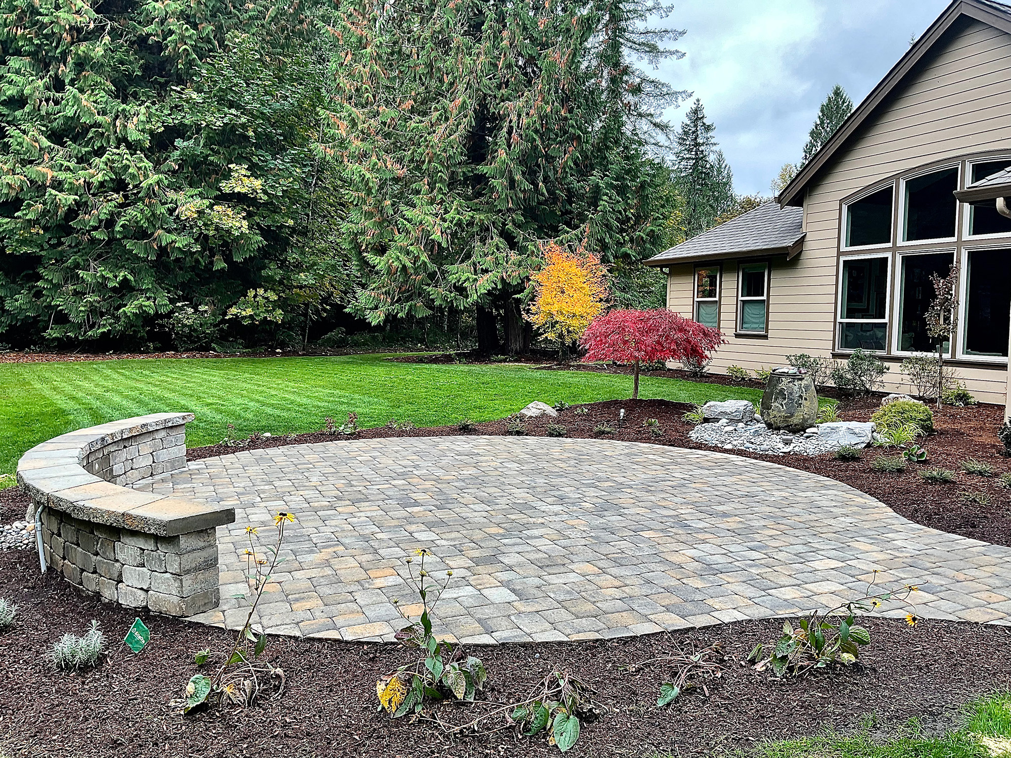 circular patio with bench by Greenhaven Landscapes