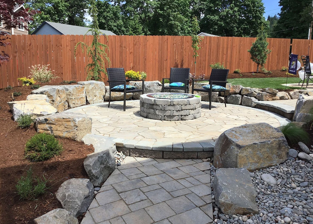 a walkway leading to a circular patio with fire pit by Greenhaven Landscapes